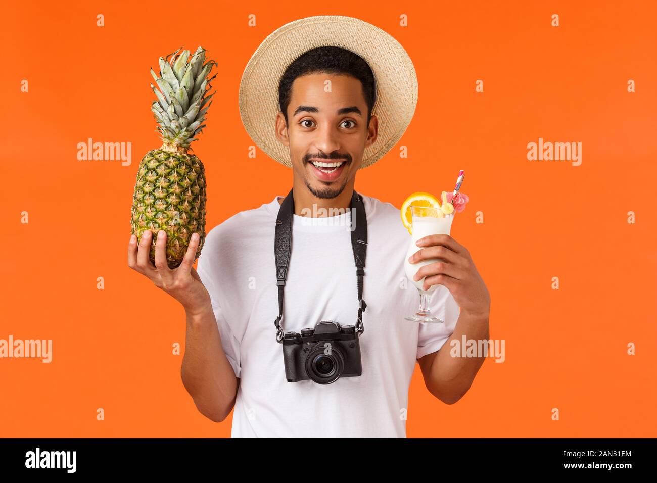 Beau sympa et amusé, smiling happy african-american man'voyageant à l'étranger, prendre des photos, la tenue d'ananas et cocktail, le port de c Banque D'Images