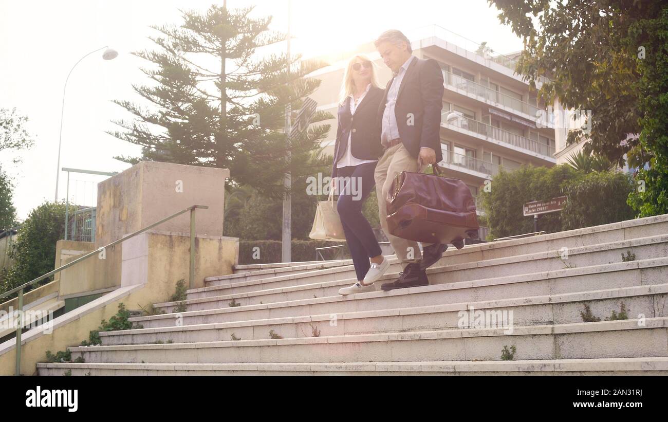 Couple de touristes en bas de marche avec sac à l'hôtel, voyage d'affaires Banque D'Images