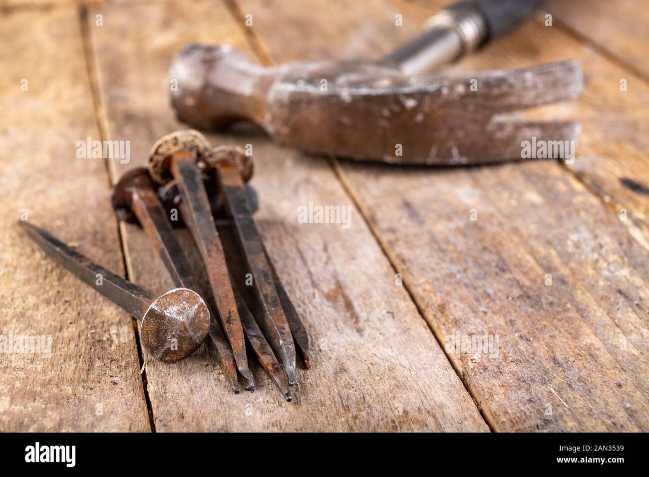 Vieux clous rouillés sur un établi. Éléments en acier forgé dans la vieille  technologie pour rejoindre le bois. Place - atelier de menuiserie Photo  Stock - Alamy