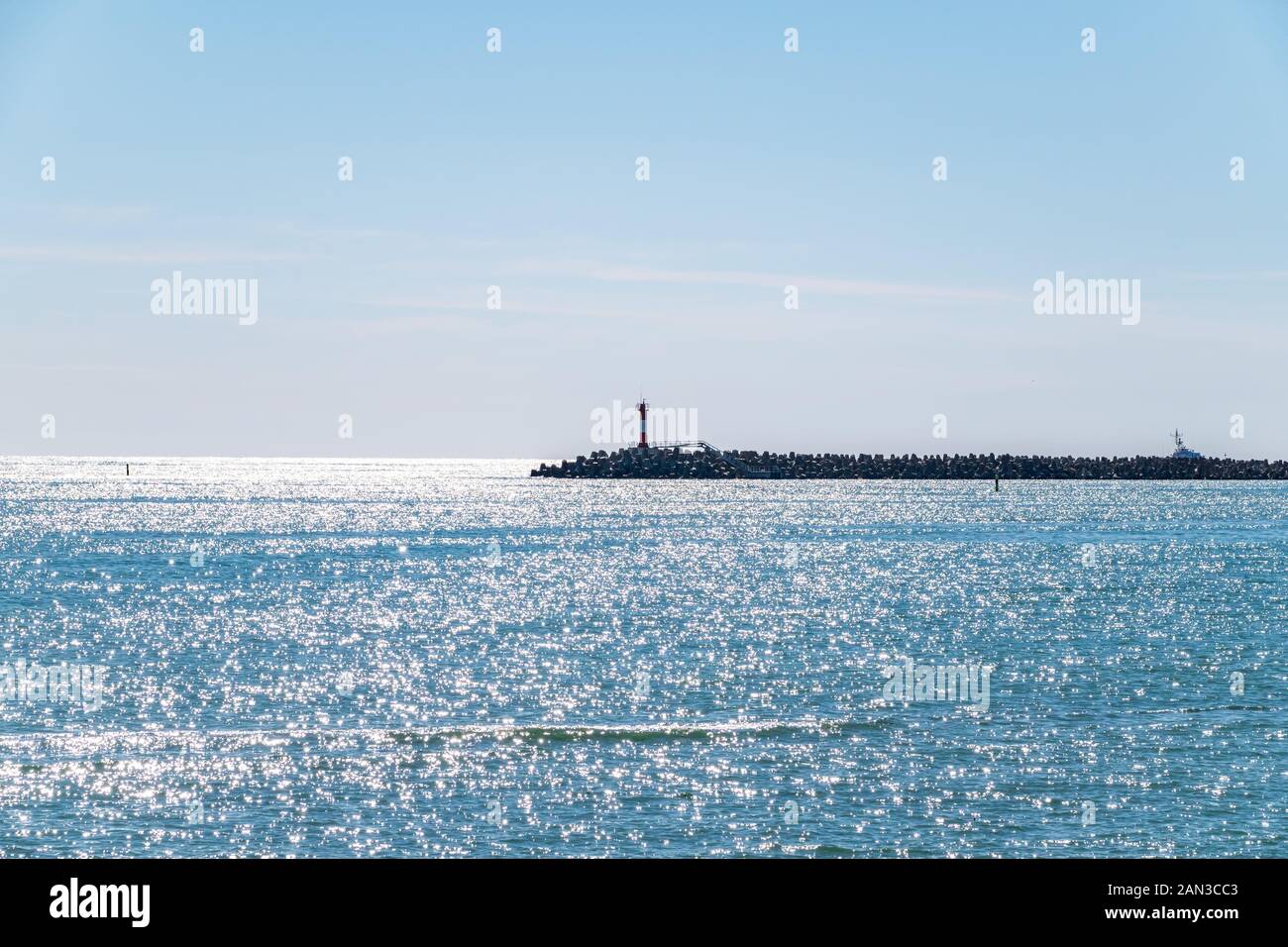 Ciel clair au-dessus de la mer avec un brise-lames et un phare. Arrière-plan de l'espace de copie Banque D'Images