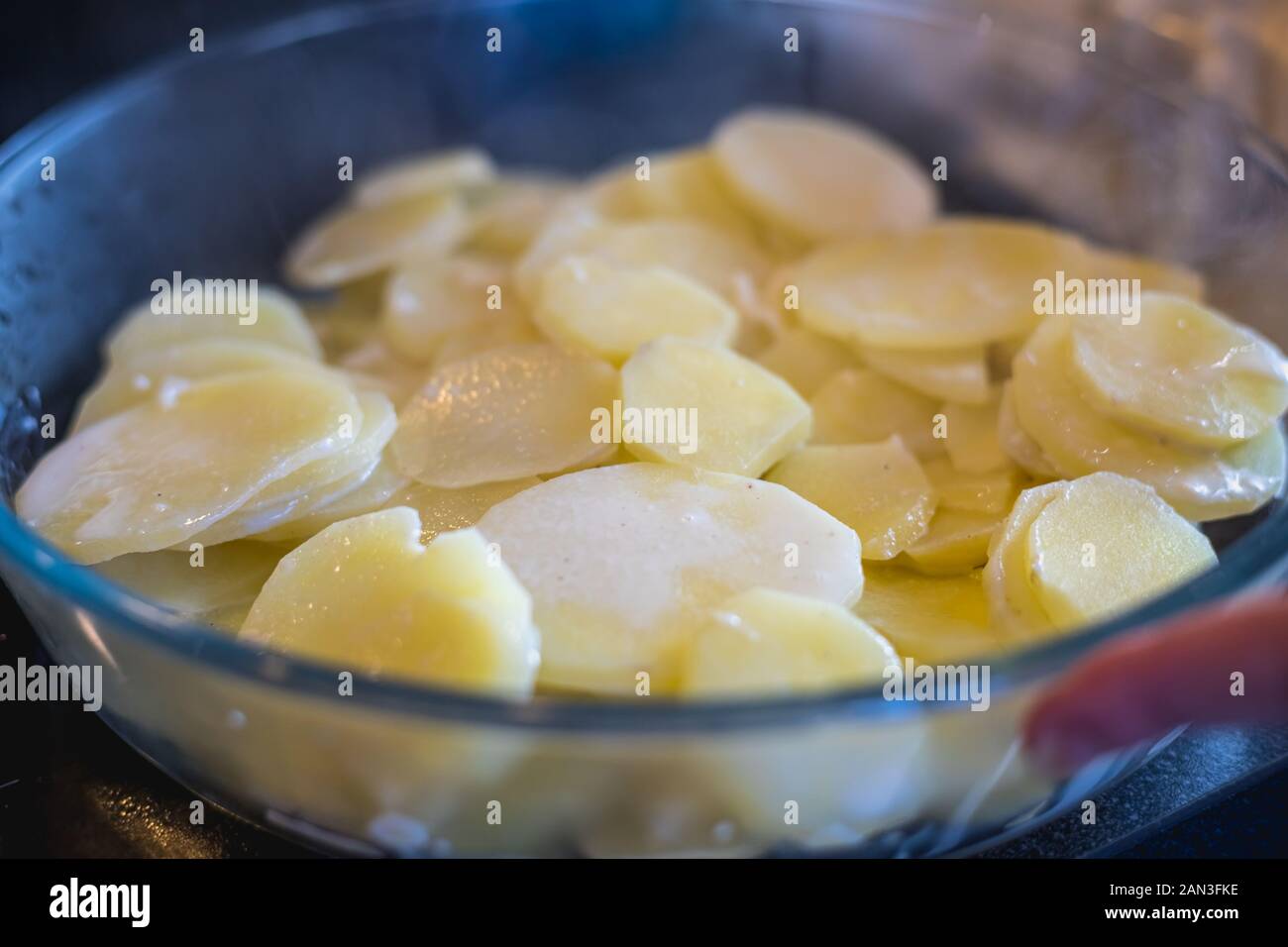 Préparation d'un gratin dauphinois avec ses pommes de terre, sa crème