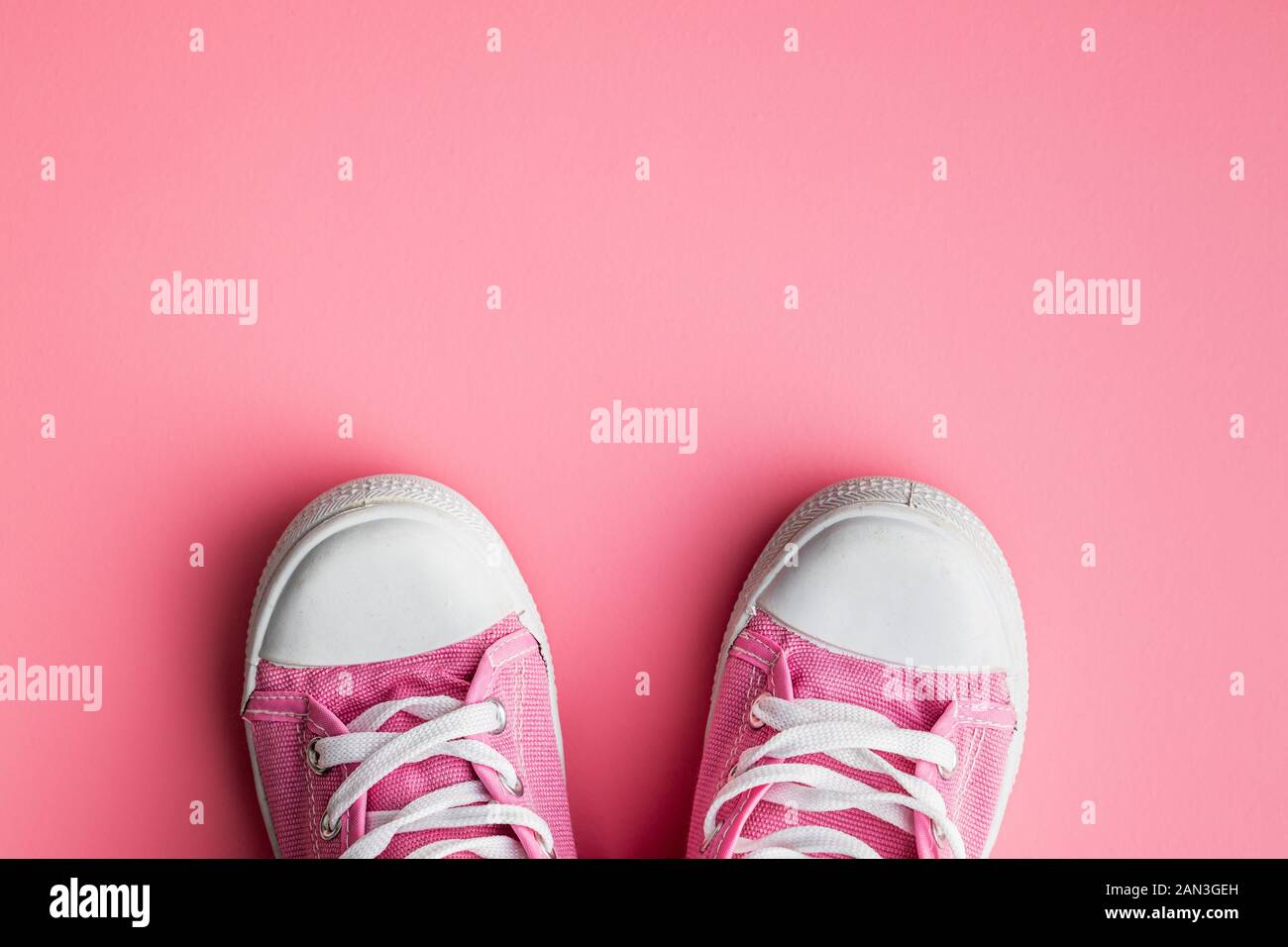 Baskets rétro. Chaussures de tennis sur fond rose. Vue de dessus. Banque D'Images