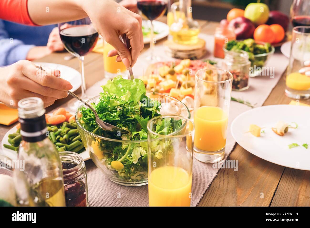 Les gens assis à la maison derrière la table, manger des aliments frais et sains Banque D'Images