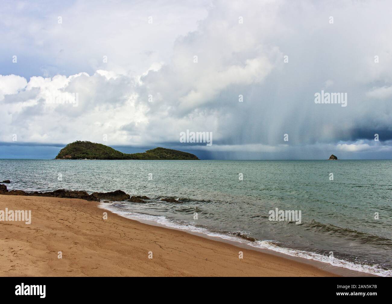 Saison des pluies tropicales bourrasque de pluie s'abattant sur Double Island off Palm Cove juste au nord de Cairns en far north Queensland Australie Banque D'Images