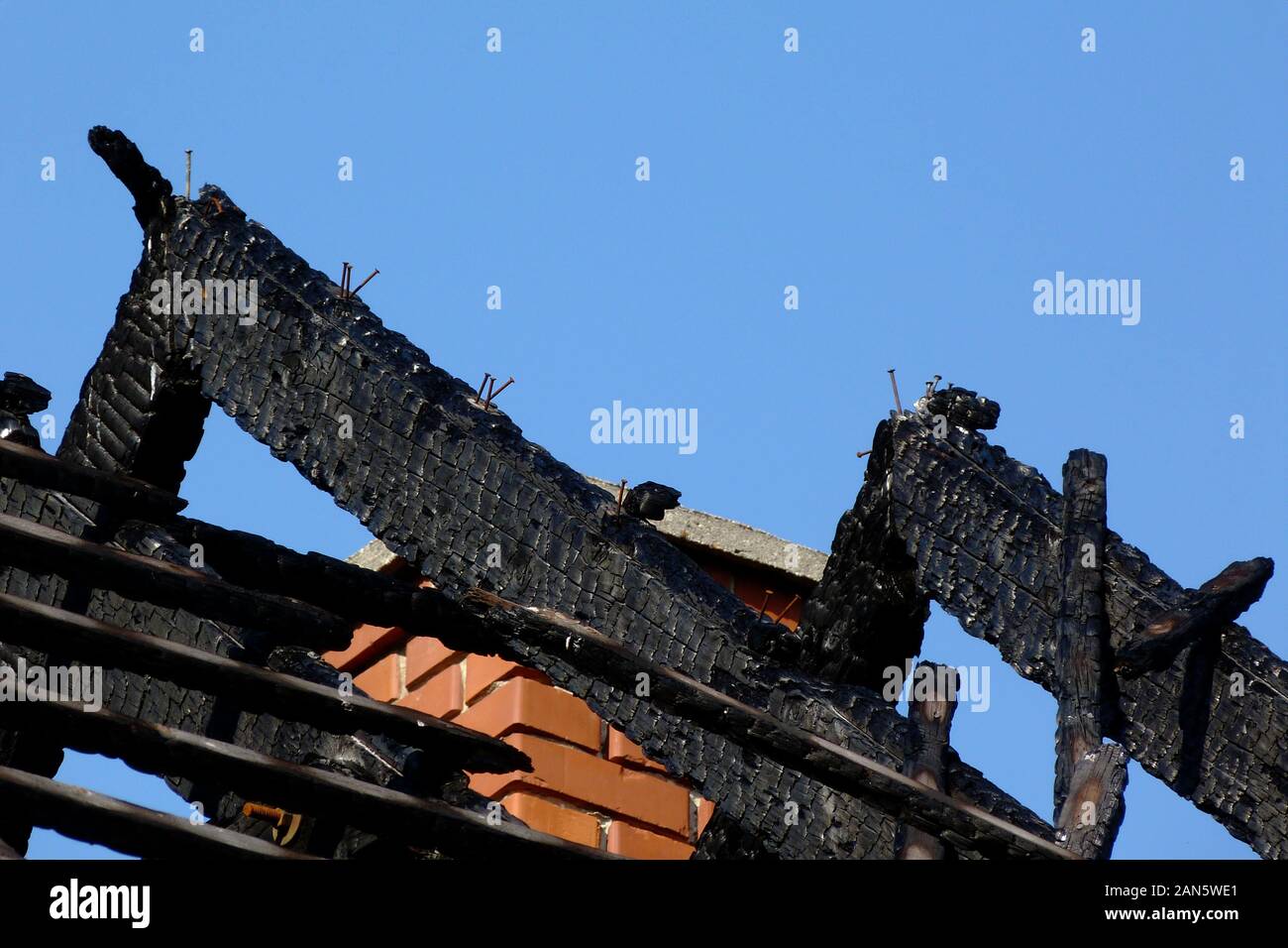 Burnt black calcinés exposés endommagé la structure du toit en bois après incendie. fire bois endommagé chevrons. ciel bleu. la sécurité incendie et de concept d'assurance. Banque D'Images