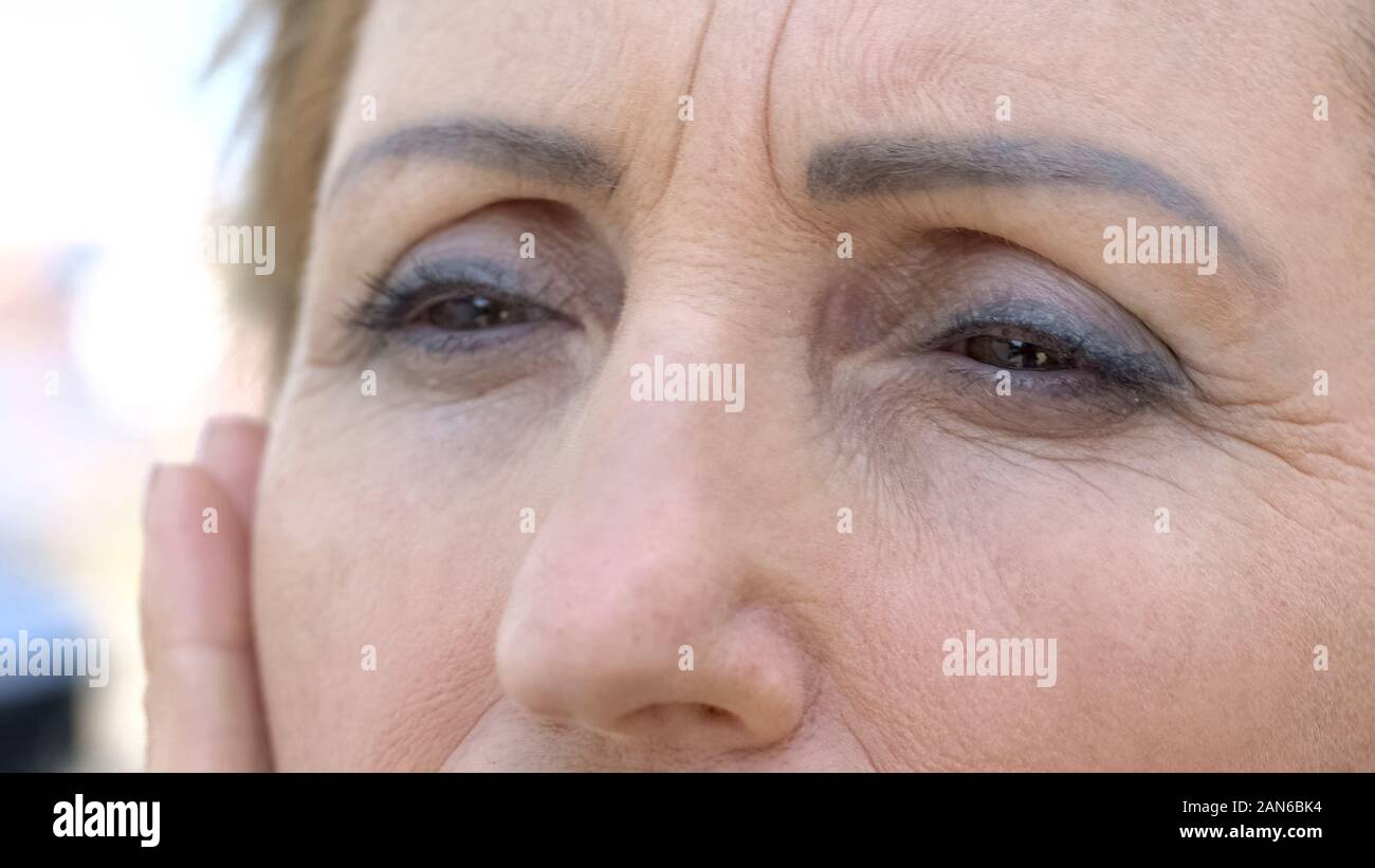 Senior woman touching her face ridée, processus du vieillissement de la peau, le désir d'être jeune Banque D'Images