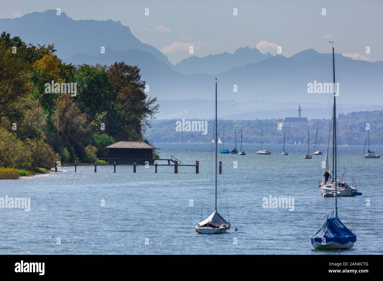 Vue sur le lac avec des voiliers et une maison de bateaux. Contexte: alpes bavaroises avec la plus haute montagne germanique, la Zugspitze et Marienmünster Dießen Banque D'Images