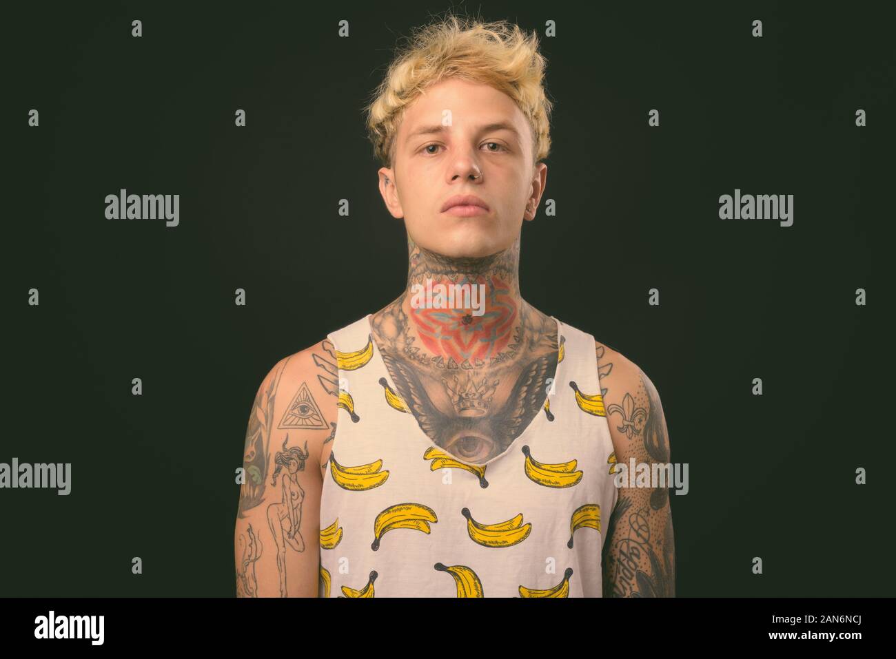 Beau jeune homme rebelle aux cheveux blonds sur fond noir Banque D'Images