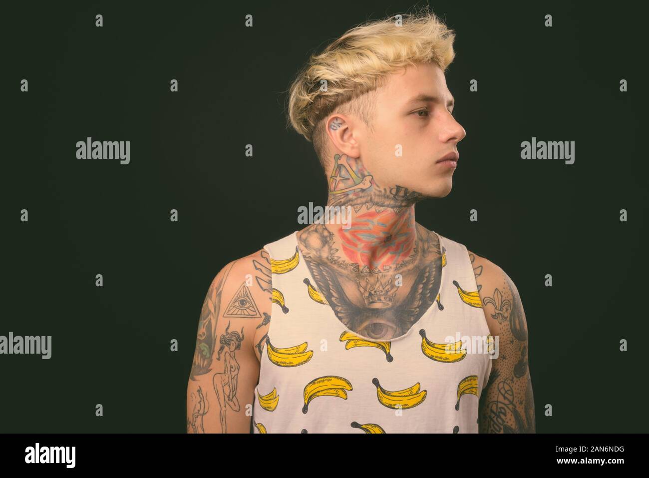 Beau jeune homme rebelle aux cheveux blonds sur fond noir Banque D'Images