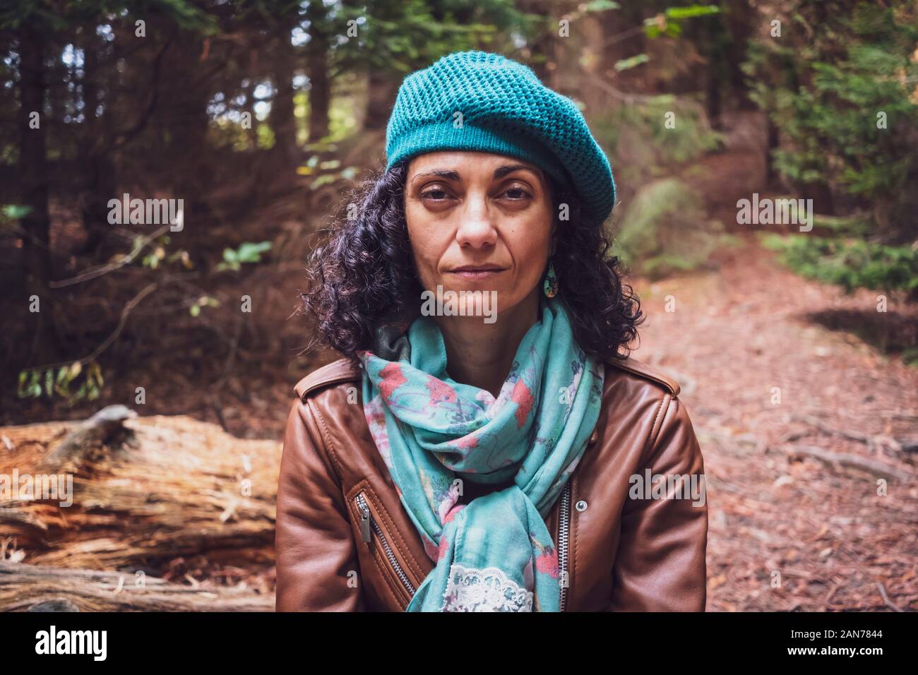 Portrait de femme blanche d'âge moyen portant un blouson de cuir brun et béret vert dans les bois Banque D'Images