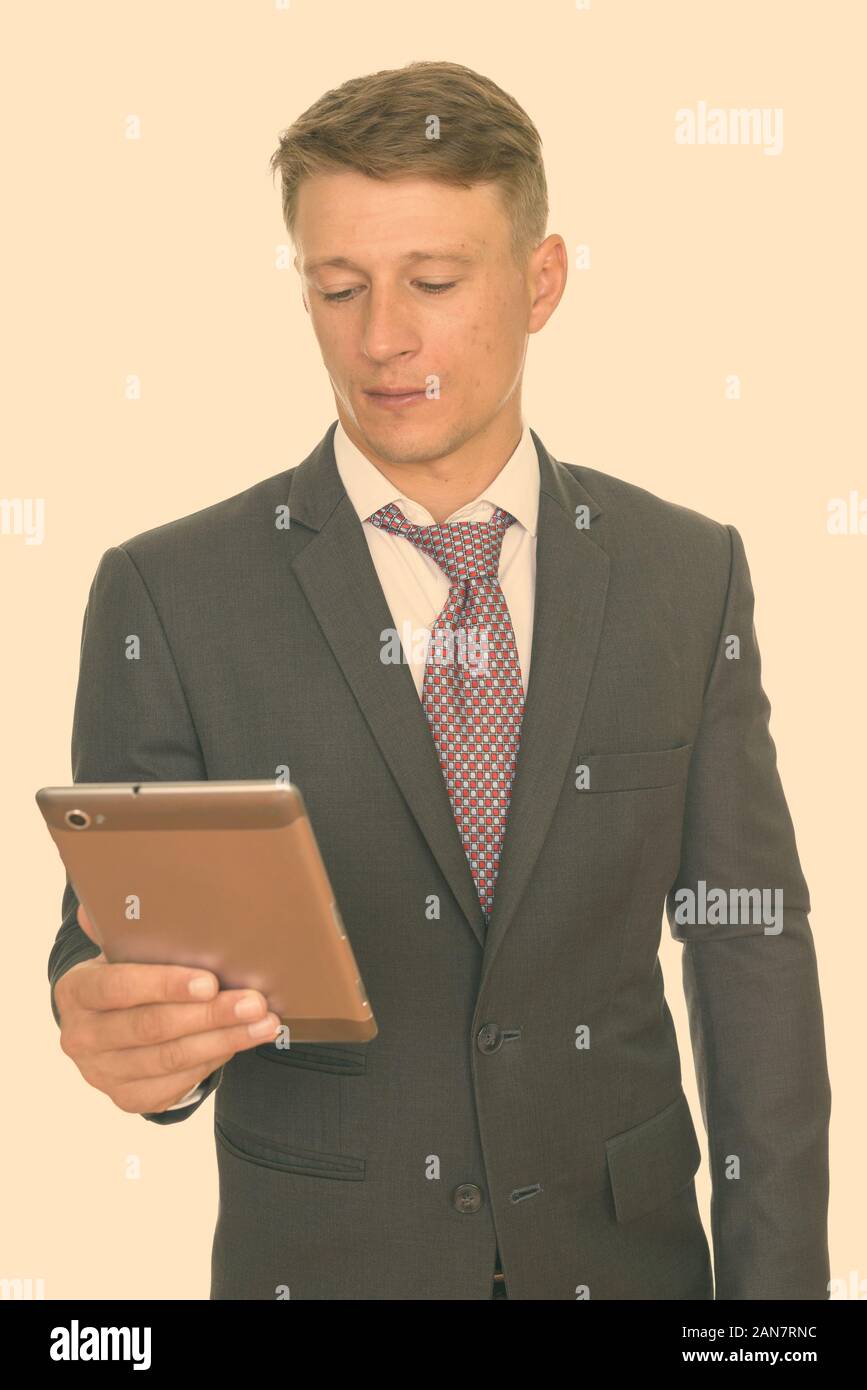 Studio shot of young handsome businessman using digital tablet Banque D'Images
