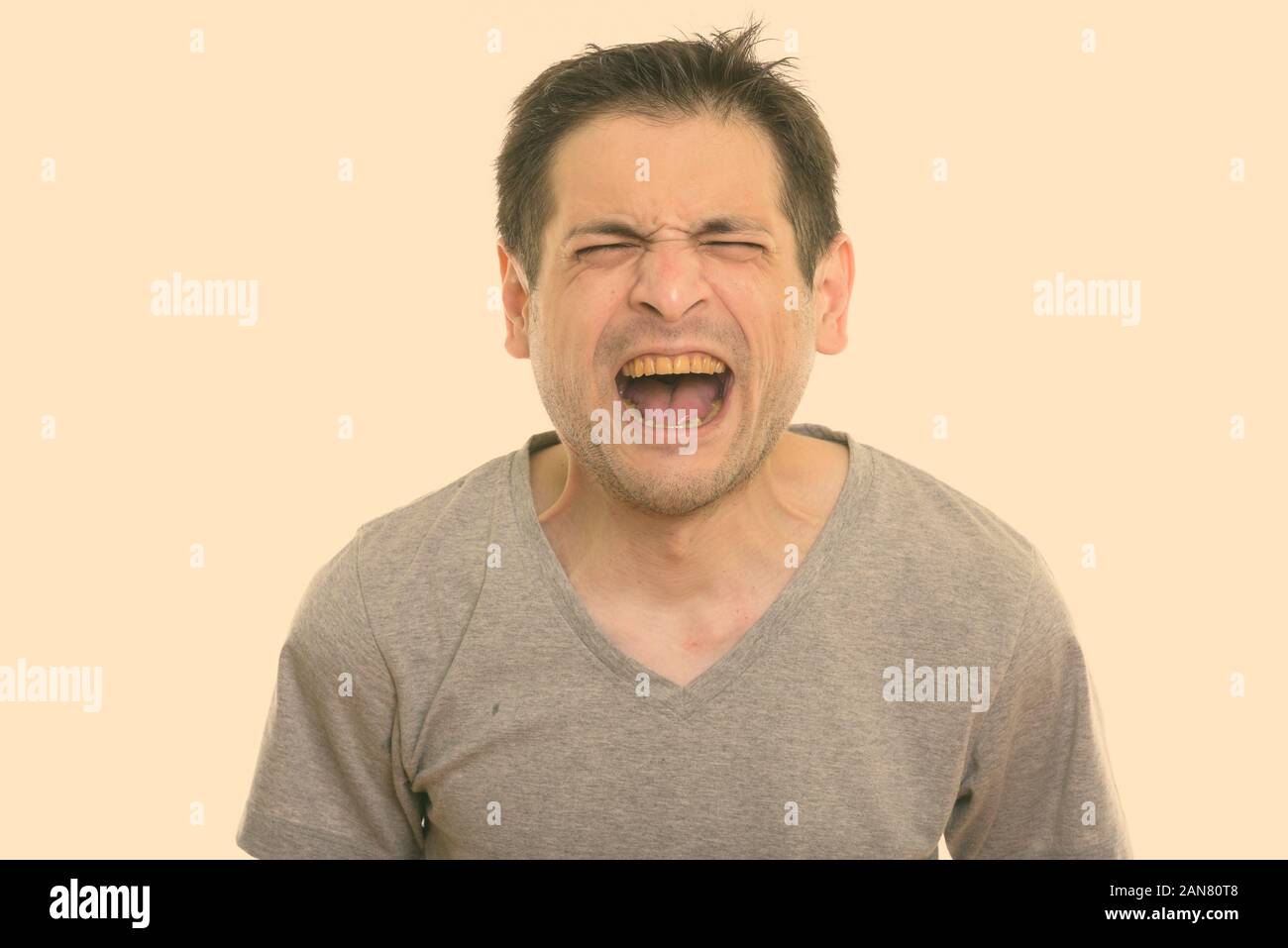 Portrait de jeune homme en colère crier avec les yeux fermé Banque D'Images