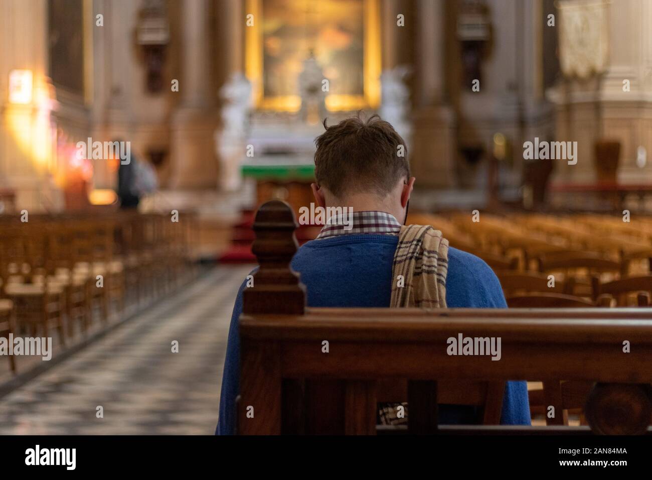 Homme priant dans une église Banque D'Images