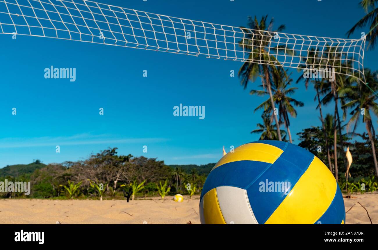 Le beach-volley. Balle de jeu en vertu de la lumière du soleil et ciel bleu avec filet de volley-ball sur l'arrière-plan Banque D'Images