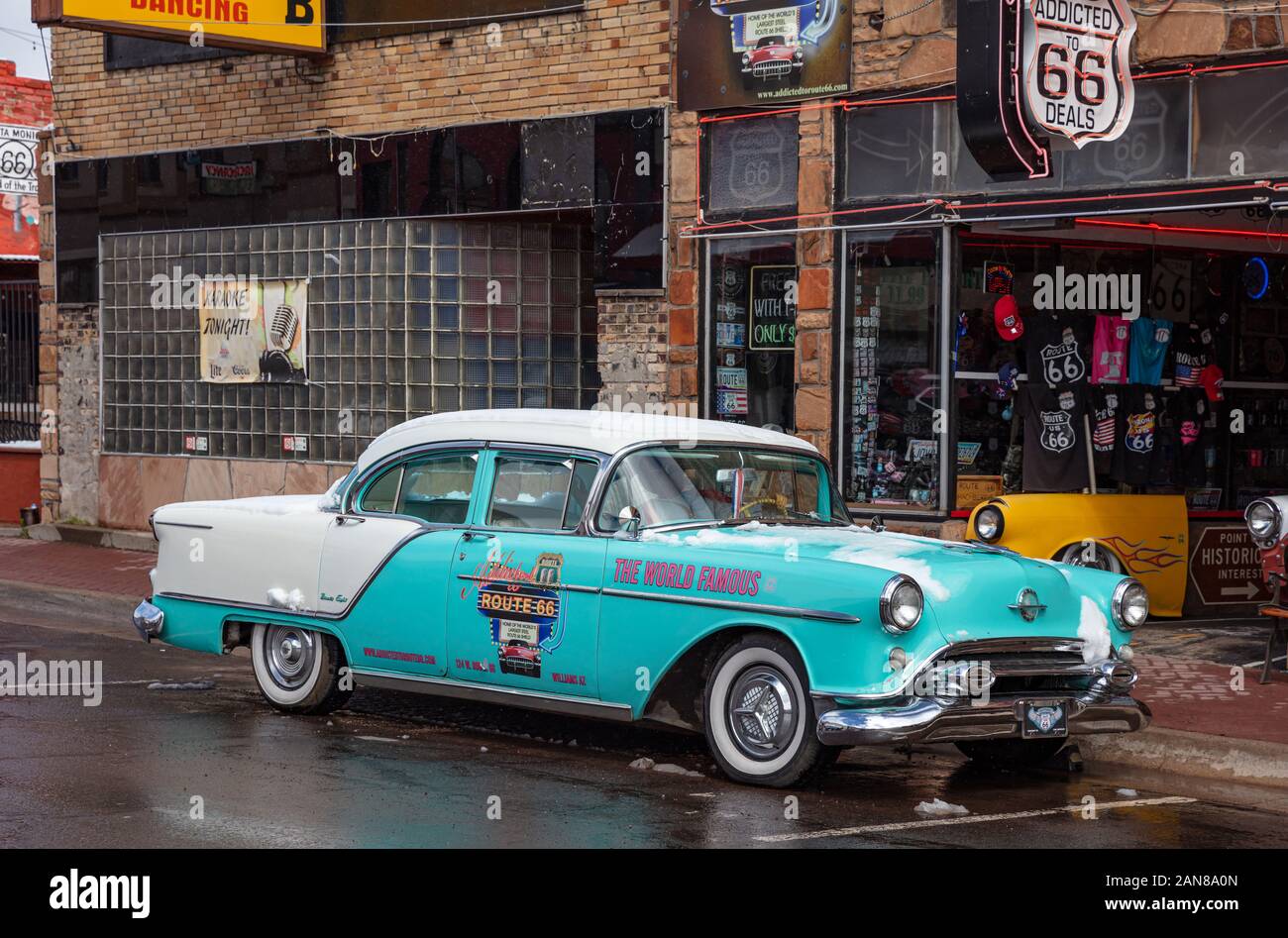 Williams, Arizona, USA. 23 mai, 2019. Antique bleu voiture est garée, un jour de neige, en face d'une boutique de souvenirs dans la ville, sur la célèbre Route 66. Vieille brique Banque D'Images