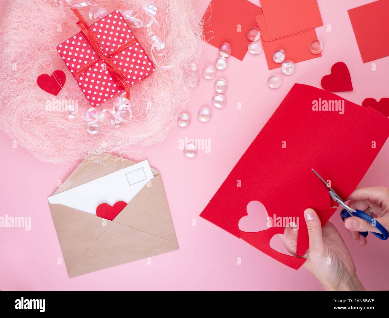 Femme se coupe en feutre rouge coeurs, de l'artisanat pour la Saint-Valentin, la créativité fait main, vue du dessus Banque D'Images