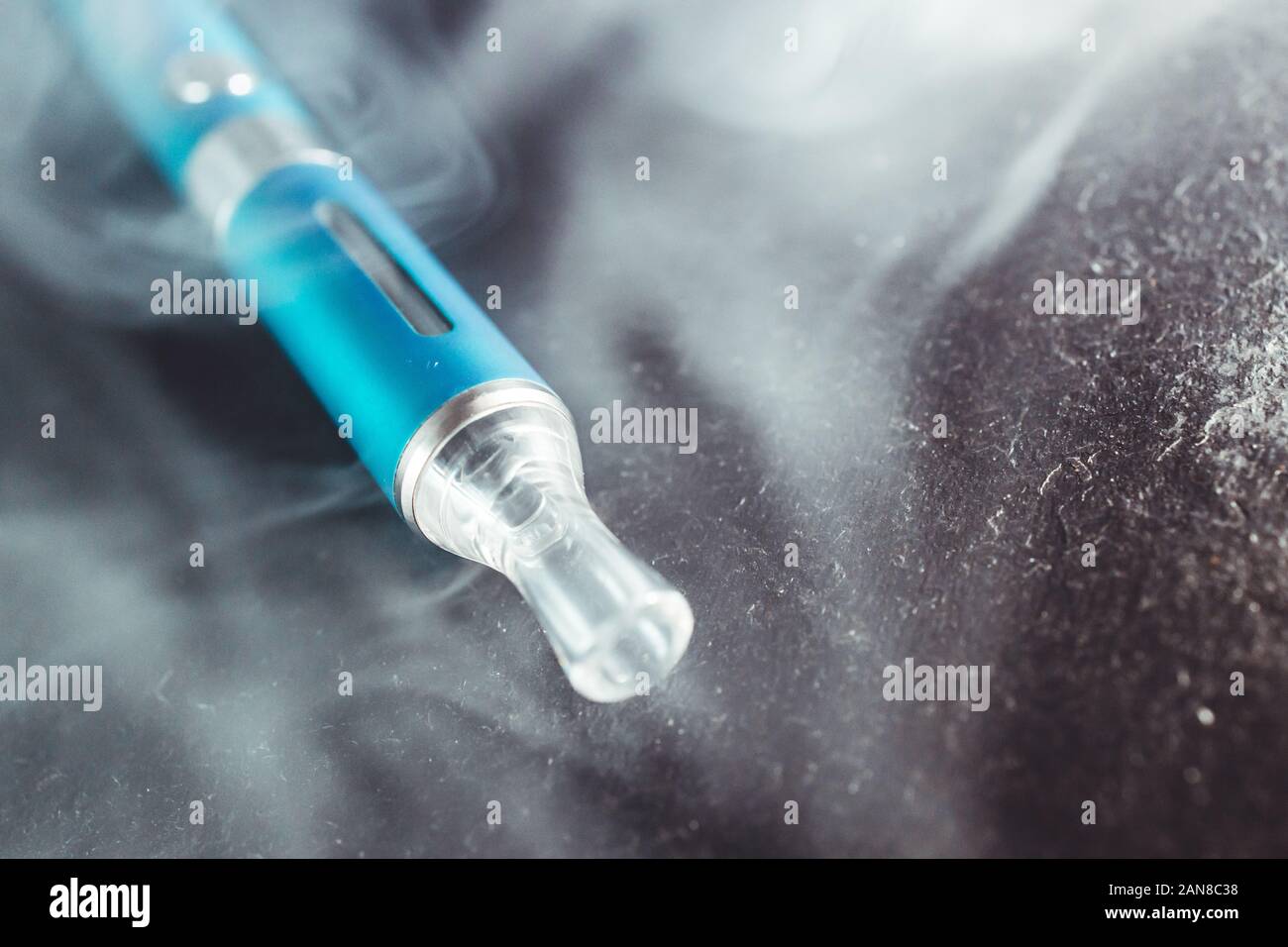Vape metal stylo cigarette électronique avec vaping nuage de fumée fond sombre Banque D'Images