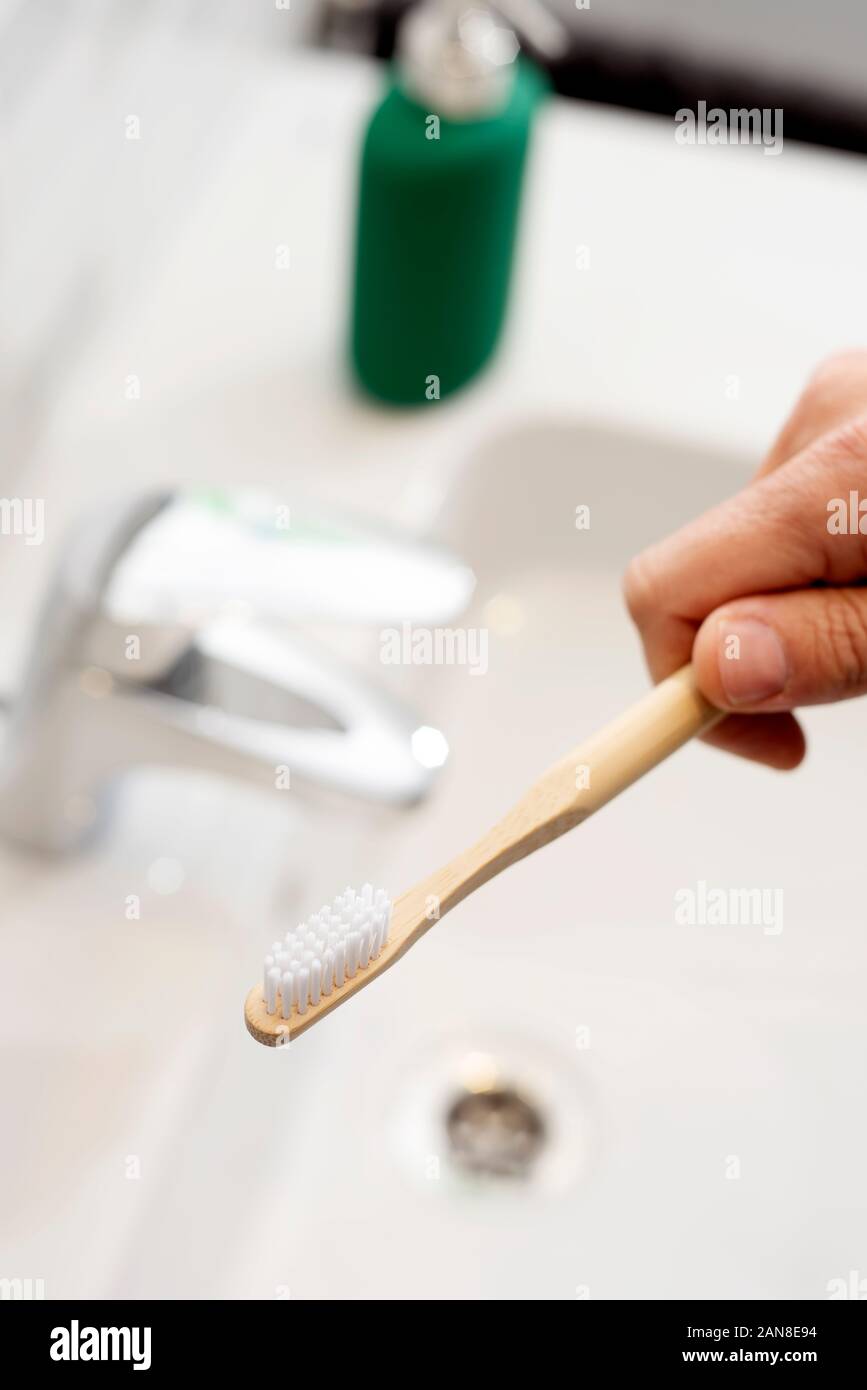 Libre d'un homme de race blanche à l'aide d'une brosse à dents dans la salle de bain en bambou Banque D'Images