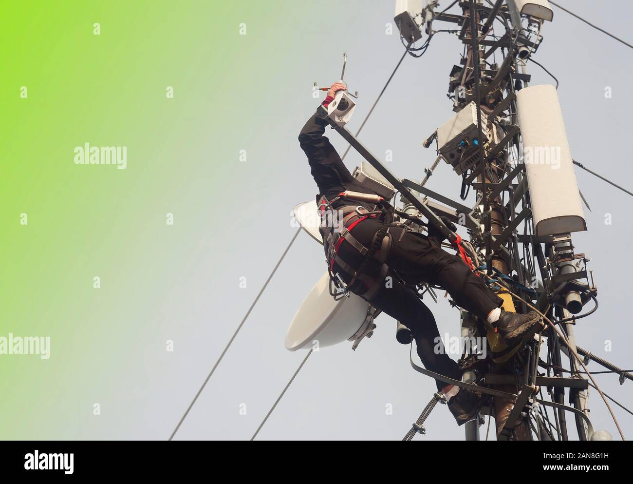 Homme électricien ou escalade alpinisme sur pôle antenne pour inspection. Résumé fond vert pour votre texte Banque D'Images