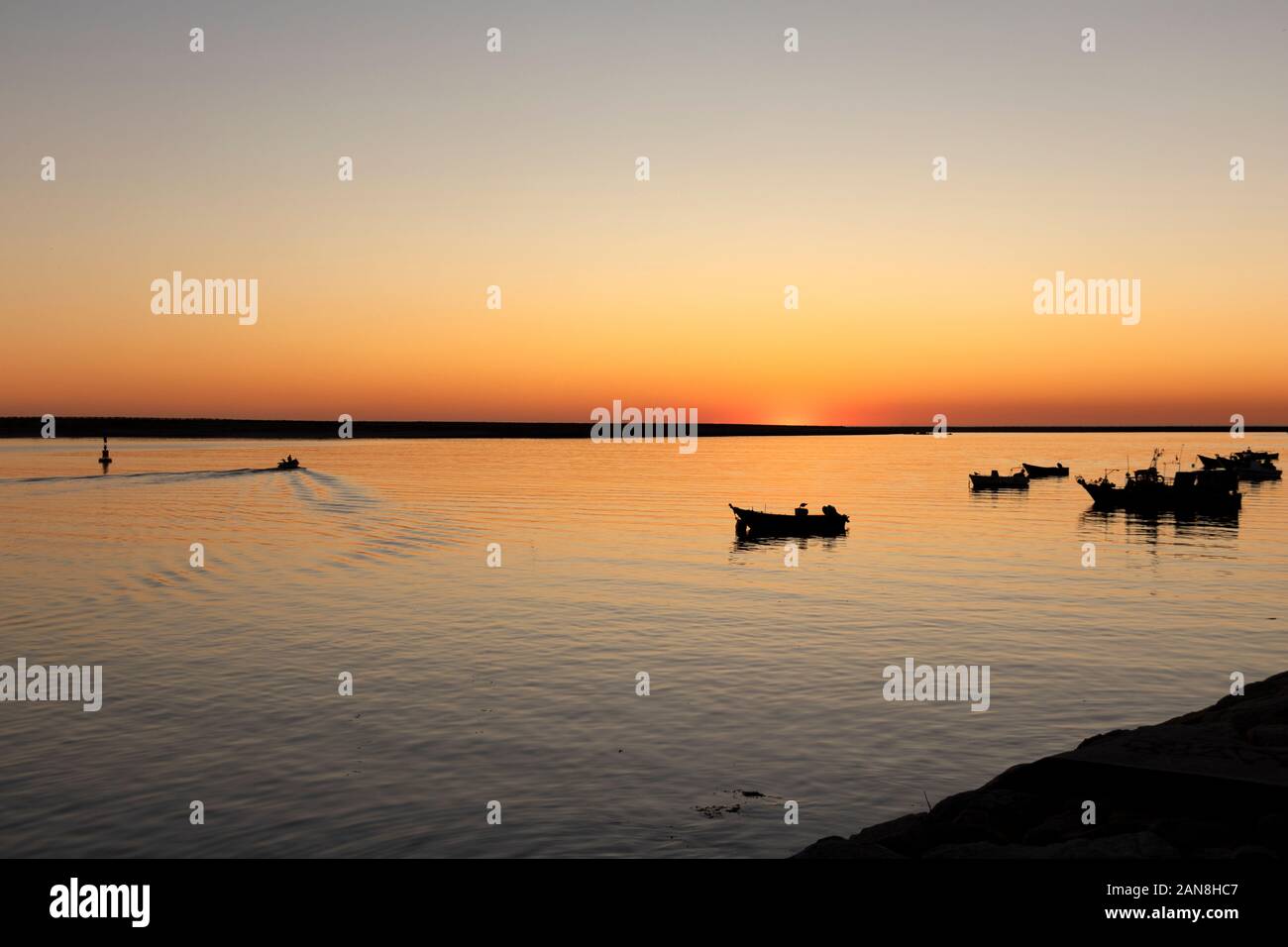 Quai avec bateaux de pêche au coucher du soleil dans l'estuaire du fleuve Douro, Porto, Portugal. Banque D'Images