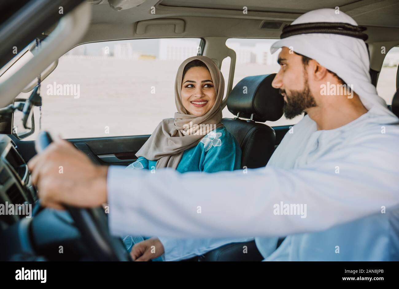 Couple heureux de conduire la voiture à Dubaï. L'homme et de la femme de sortir pour faire du shopping. Concept de relation dans les eau Banque D'Images