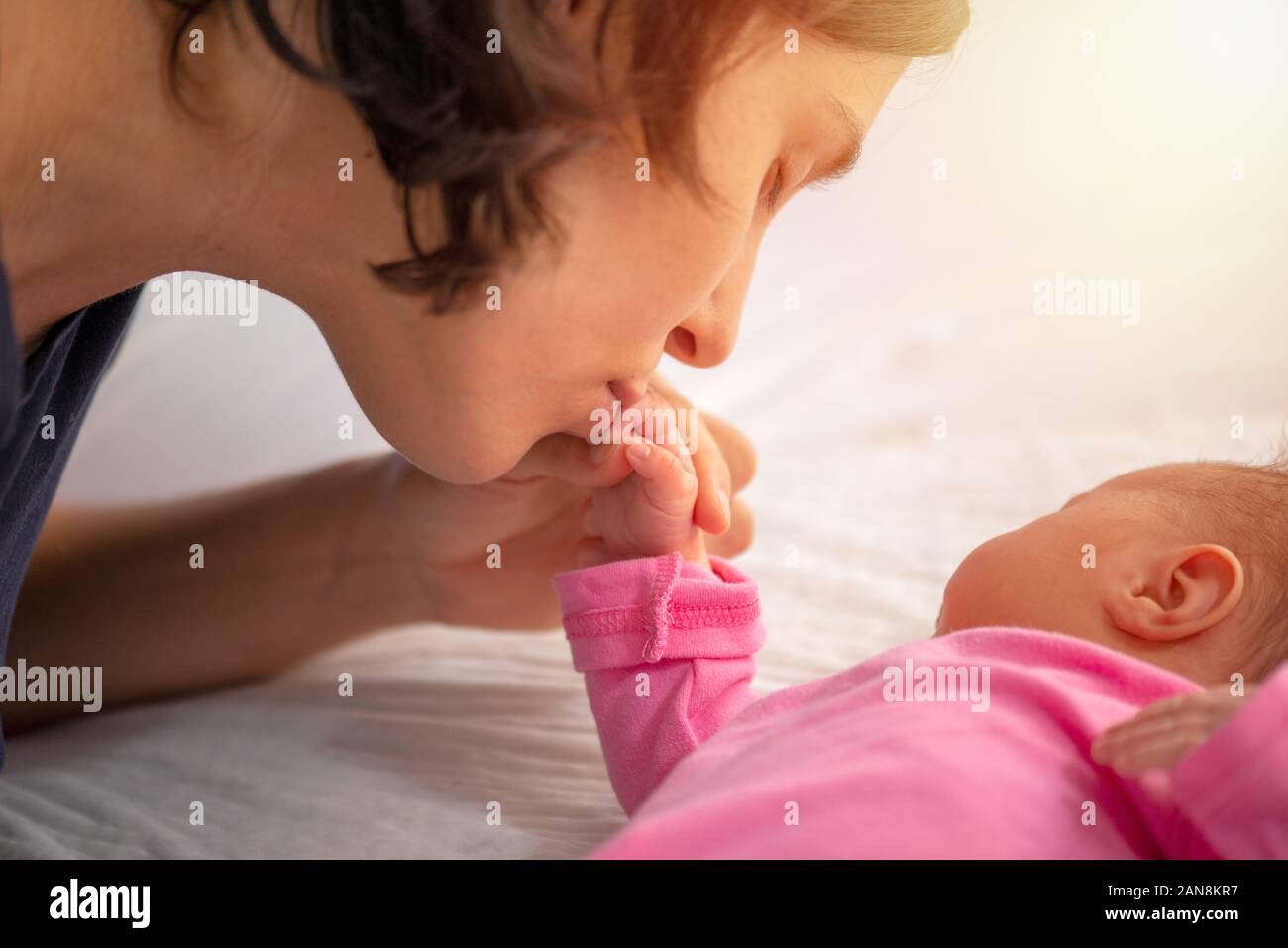 Mère embrasse la main du nouveau-né Banque D'Images