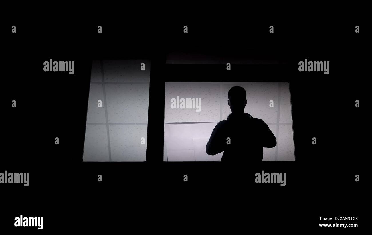 Silhouette of man patient fou dans l'asile à fenêtre, un handicap psychosocial Banque D'Images