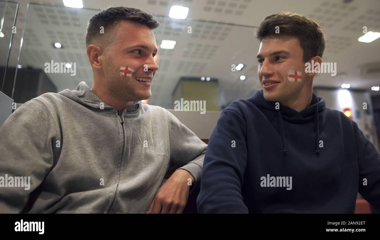 Heureux homme football fans discutant résultat de jeu, soirée dans un pub après match Banque D'Images