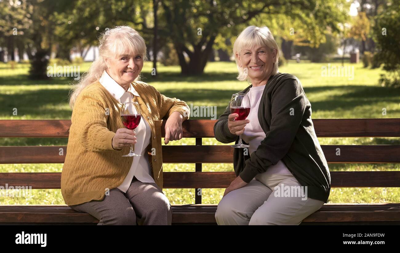 Deux amis grand-mère boire du vin et leur équipe de caméra, heureux d'or Banque D'Images