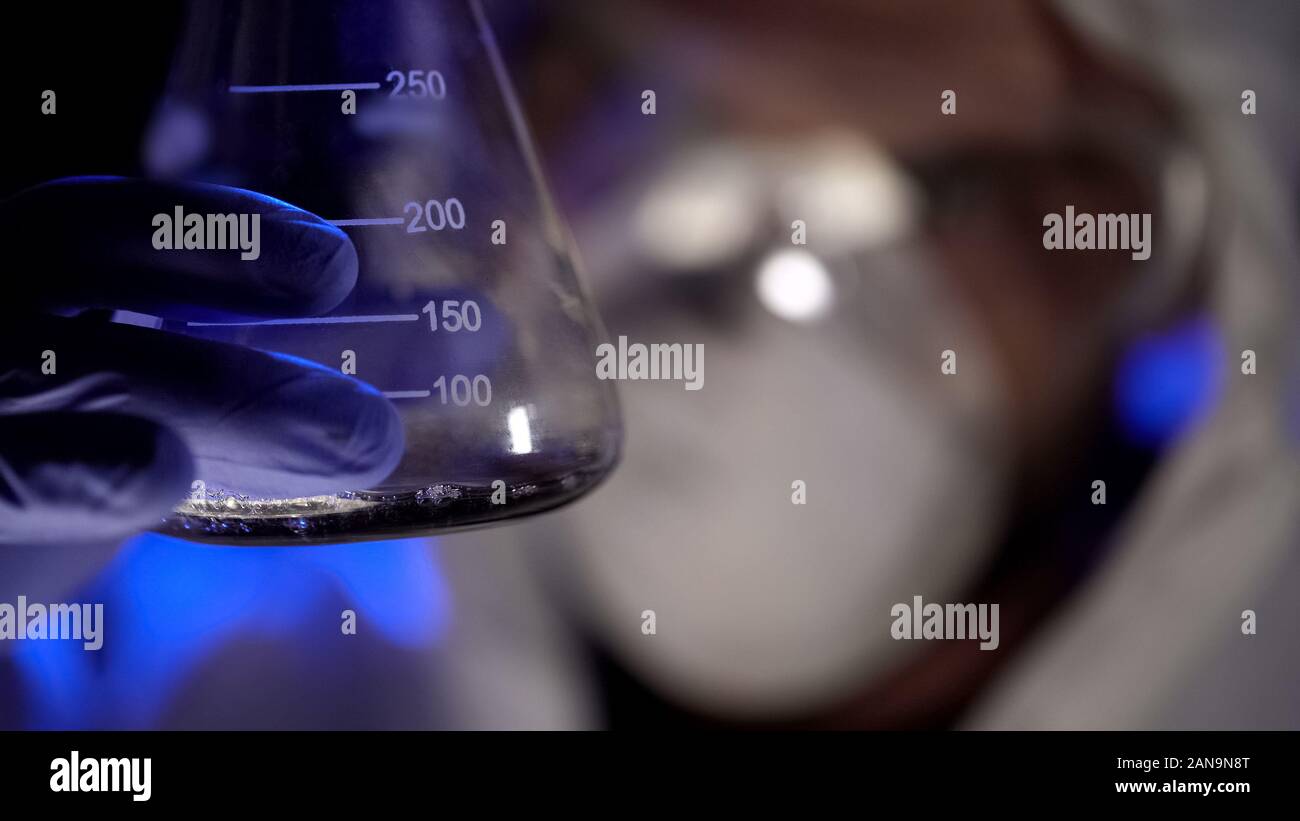 Chemist holding test tube avec du liquide, l'analyse de résultat de l'essai, les armes biologiques Banque D'Images