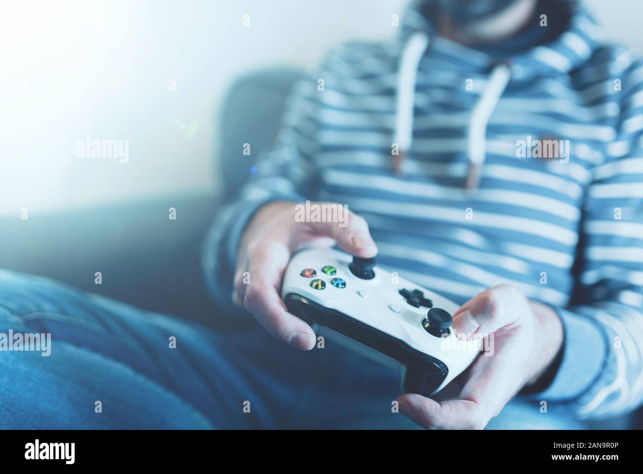Portrait de l'homme posé sur table à l'aide de la manette sans fil pour jouer à des jeux vidéo Banque D'Images