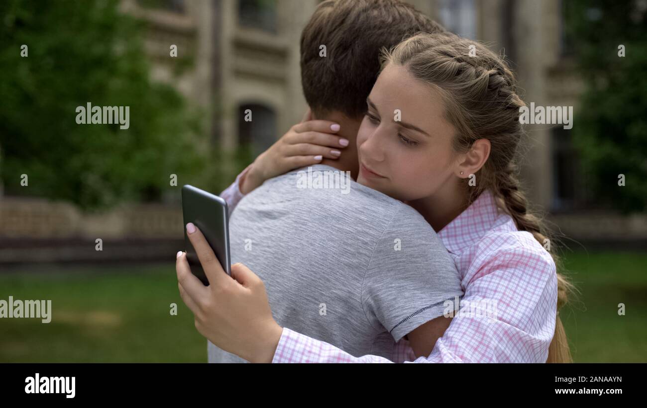 Fille de l'adolescence à l'aide de Phone, serrant petit ami au lieu d'une réelle communication, concept Banque D'Images