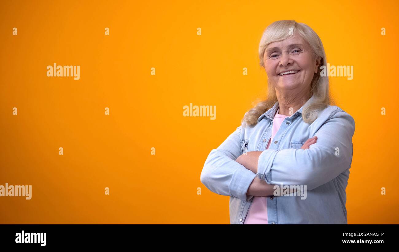 Smiling vieille femme traversant les mains sur la poitrine, entreprise prospère, heureux de l'âge adulte Banque D'Images