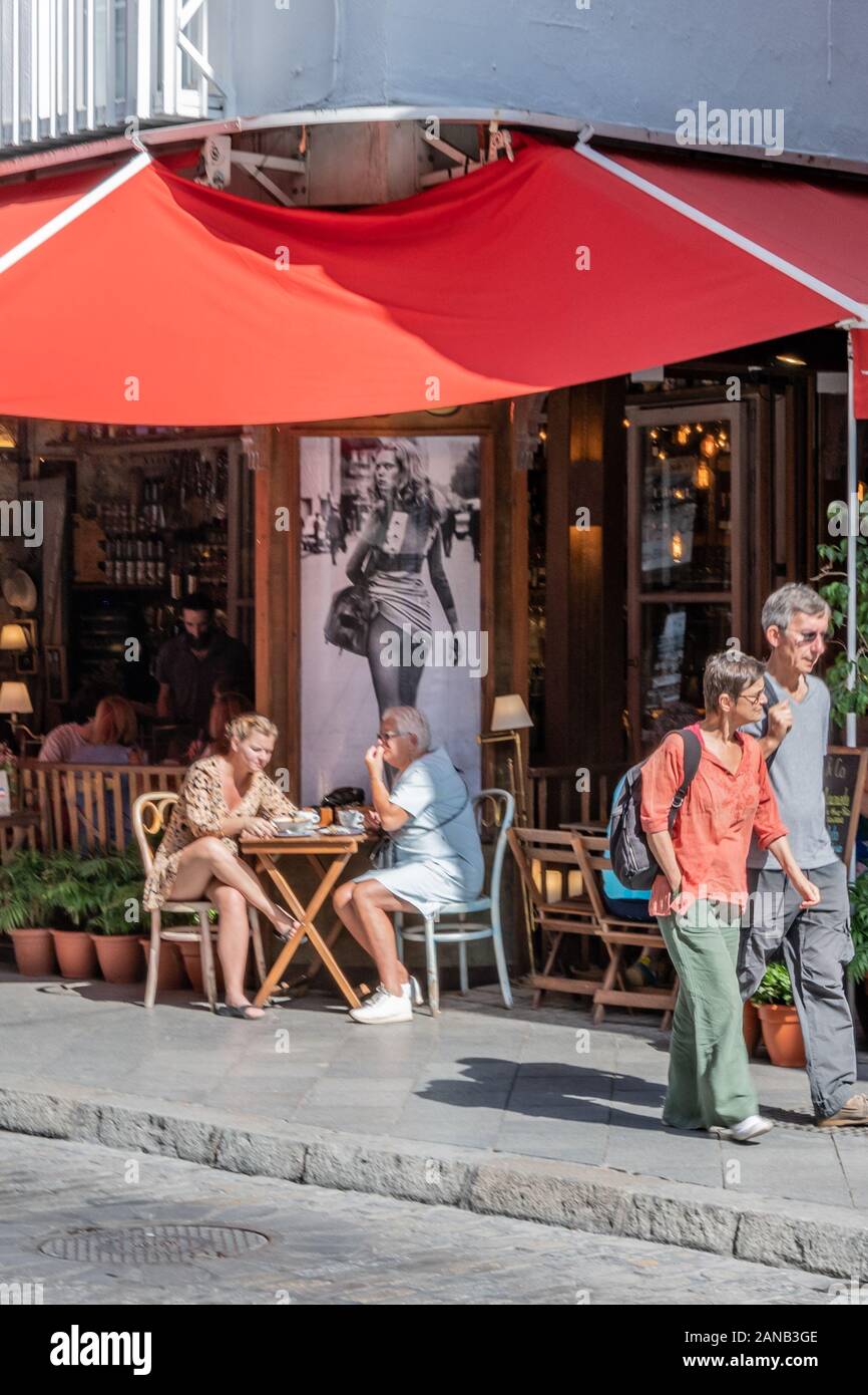 Deux femmes mangeant le déjeuner sous une affiche éky d'une jeune femme dans une robe très courte. Banque D'Images
