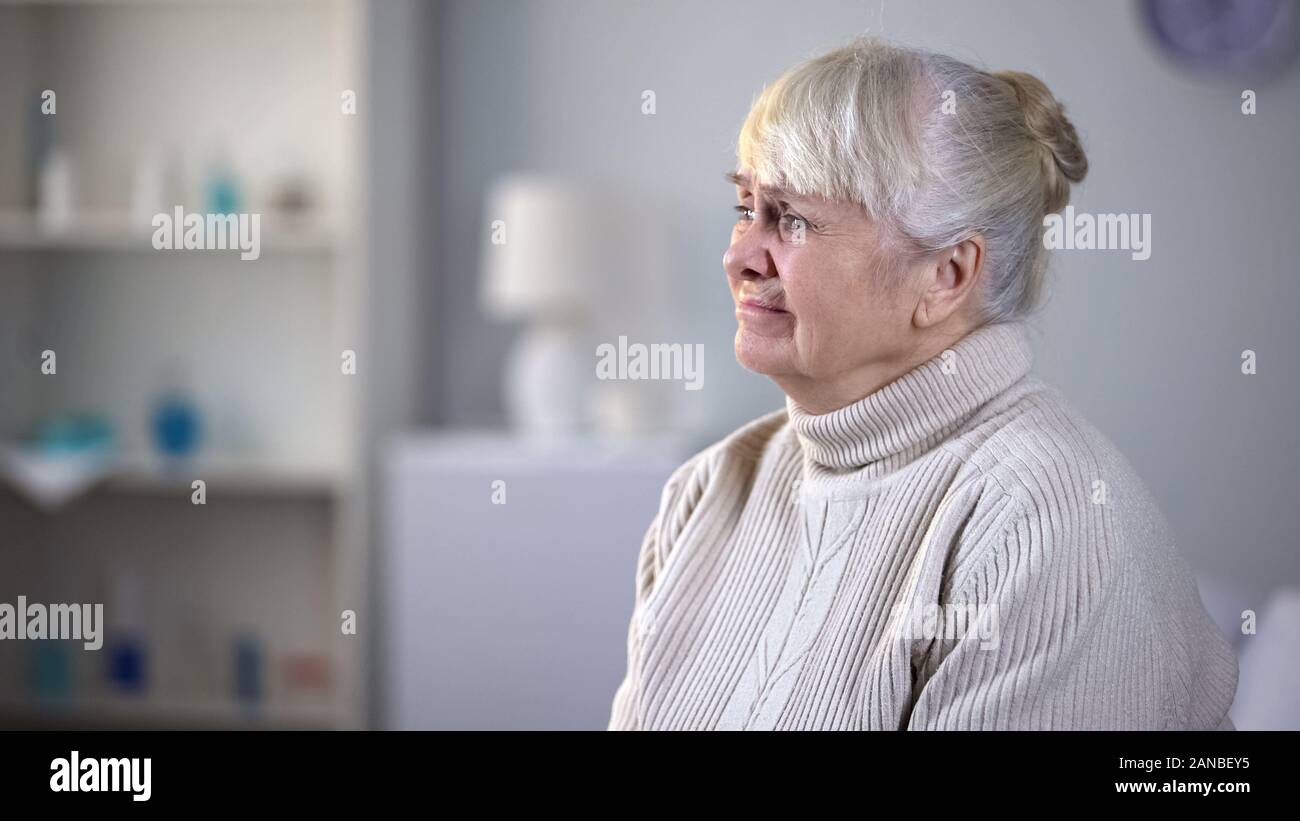 Déprimé senior woman assise seule dans la salle de séjour, abandonnés par des parents Banque D'Images