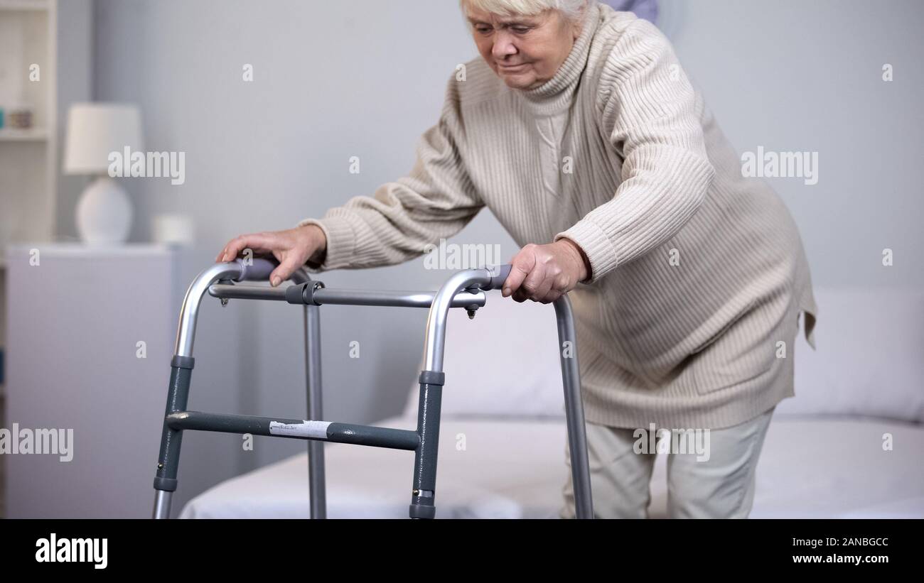 Femme âgée avec déambulateur, à l'aide de l'équipement médical de l'hôpital, après un traumatisme Banque D'Images
