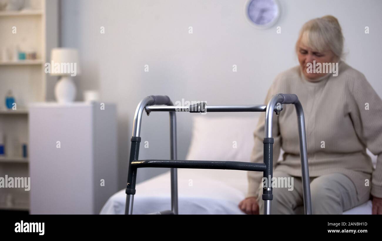 La marche de l'hôpital de l'avant du châssis de vieille dame blessés assis bed, clinique rehab Banque D'Images