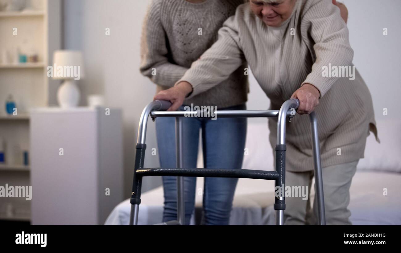 Aider les personnes âgées à l'aide de bénévoles femme déambulateur, la réadaptation après un traumatisme Banque D'Images