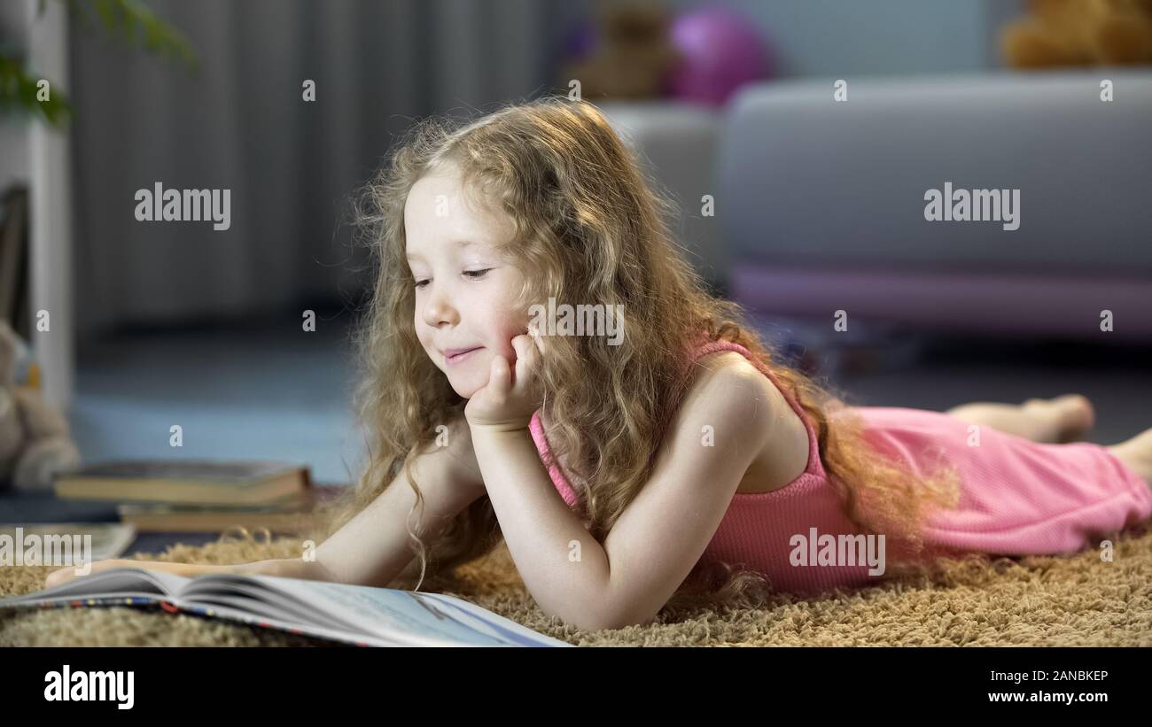 Cute little girl reading book aventureux, les dépenses de loisirs Banque D'Images