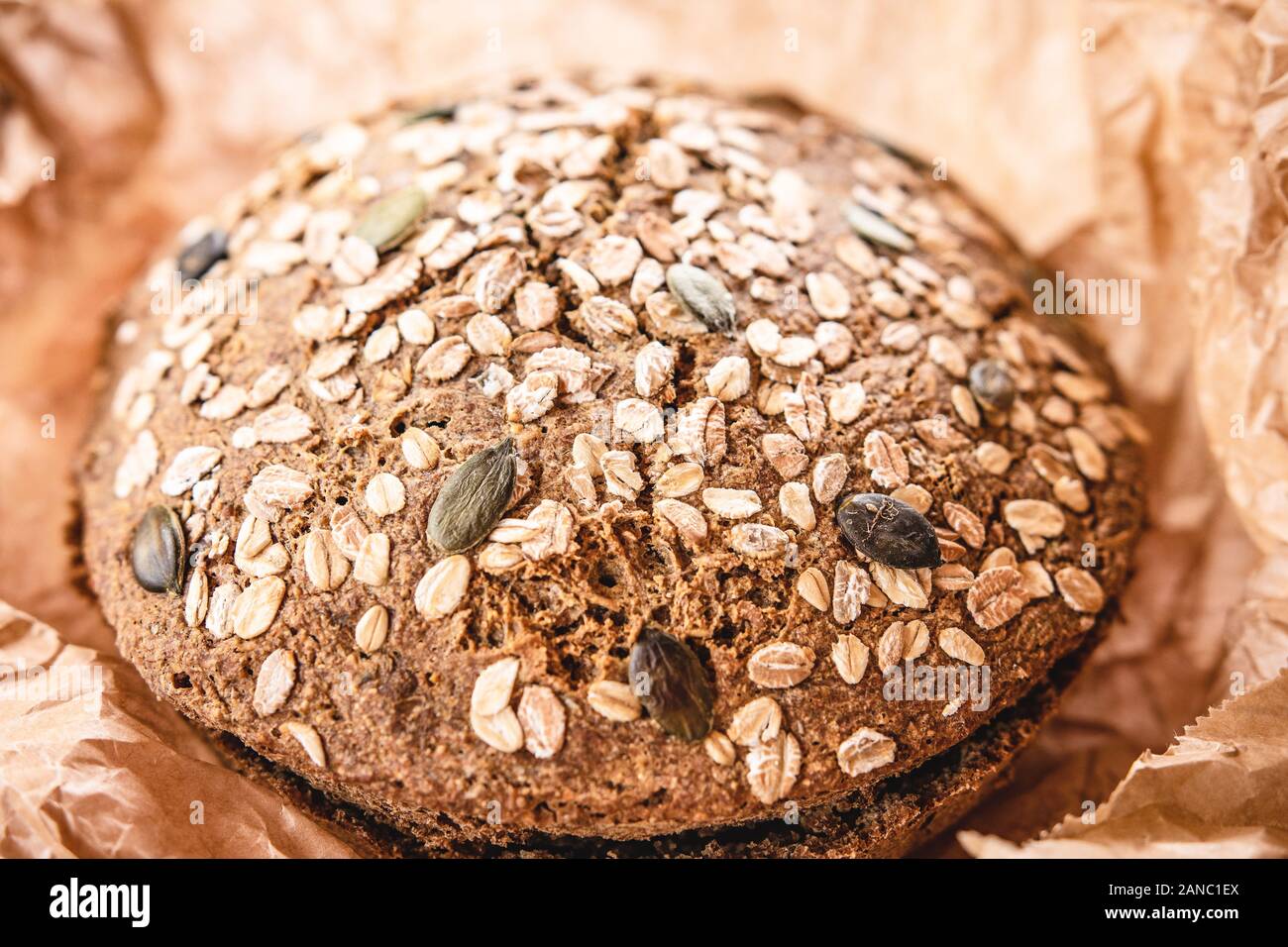 Pain de seigle traditionnel de grains entiers dans un papier parchemin brun Banque D'Images