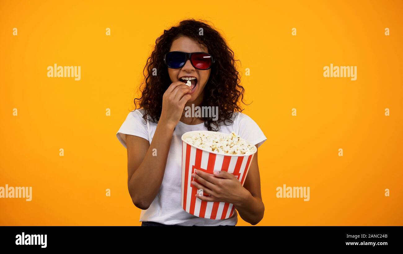 Femme afro en 3D sans lunettes eating popcorn and watching comedy show Banque D'Images
