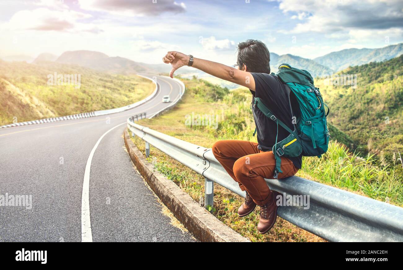 Jeune Homme Assis Sur Le Bord De La Route Vacances Et Concepts Backpacker Sur Route L Autostop Homme Voyage Photo Stock Alamy