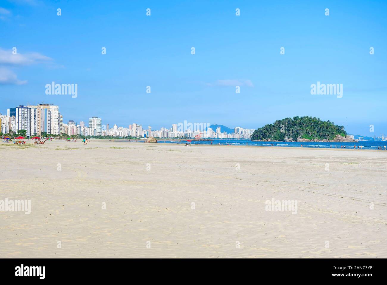 Plage brésilienne Paulista avec une immense bande de sable au bord de l'eau sur une belle journée. Photo de la plage d'Itarare, Sao Vicente ville avec la vue de Jose Menino b Banque D'Images