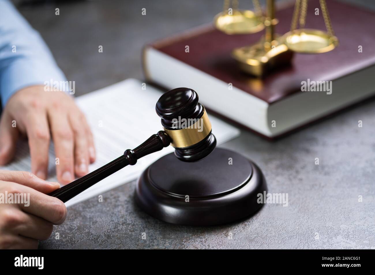 Close-up d'une main humaine Maillet frappant en face de l'échelle de pesage d'Or Banque D'Images