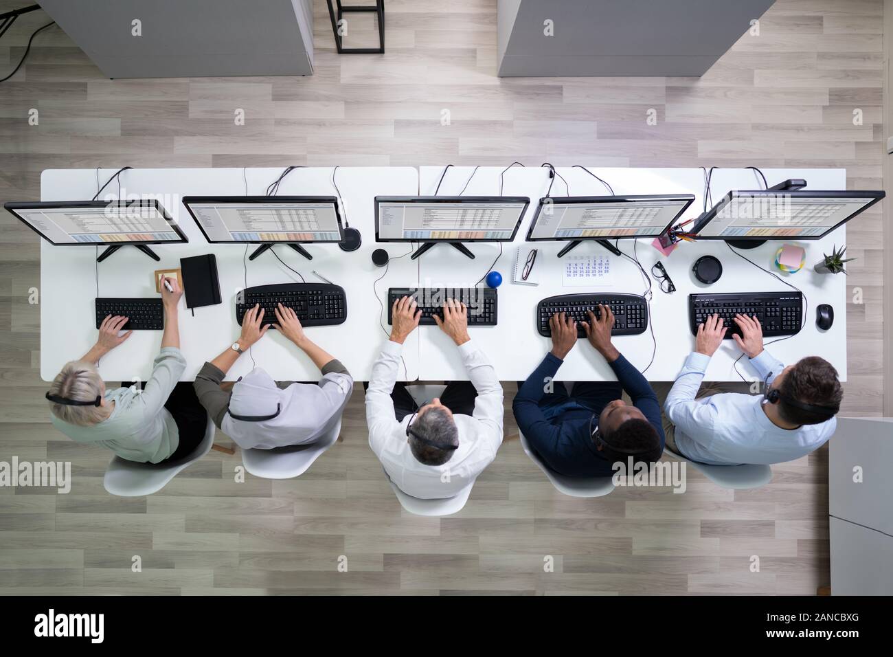 L'agent des services à la clientèle féminine positive avec casque de travail dans un centre d'appels Banque D'Images