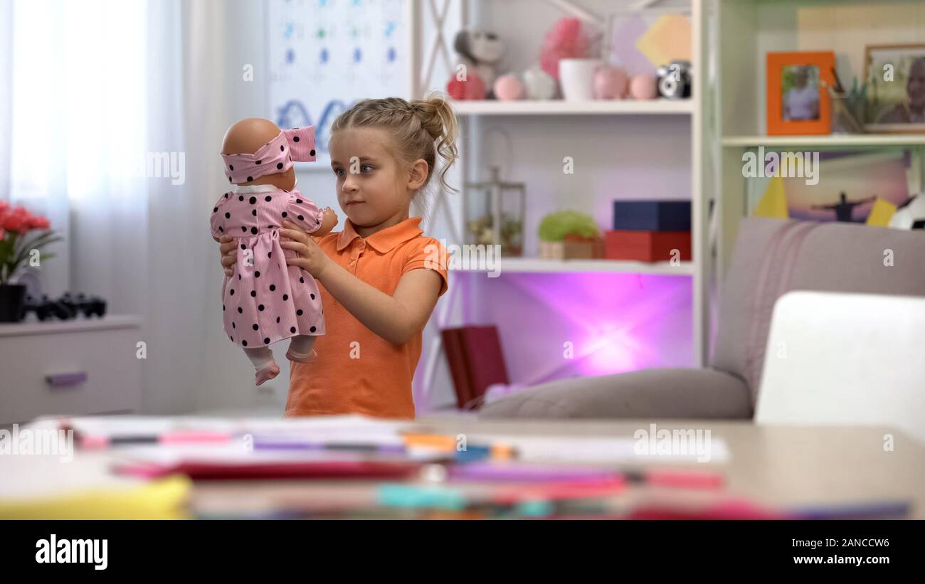 Petite fille à la tenue et au bébé, jouets loisirs fille, de l'enfance le bonheur Banque D'Images