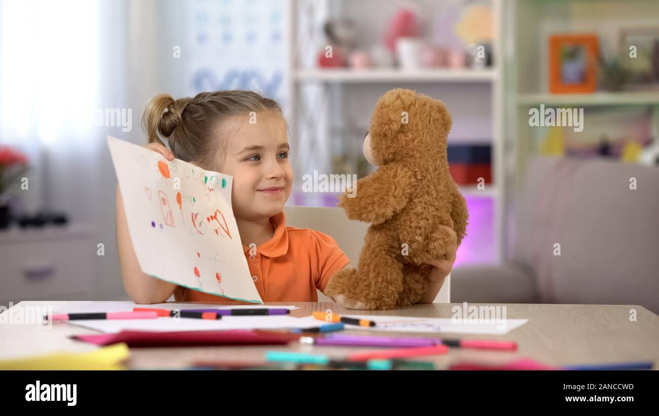 Smiling girl montrant dessins nounours, jeux, loisirs ami imaginaire Banque D'Images