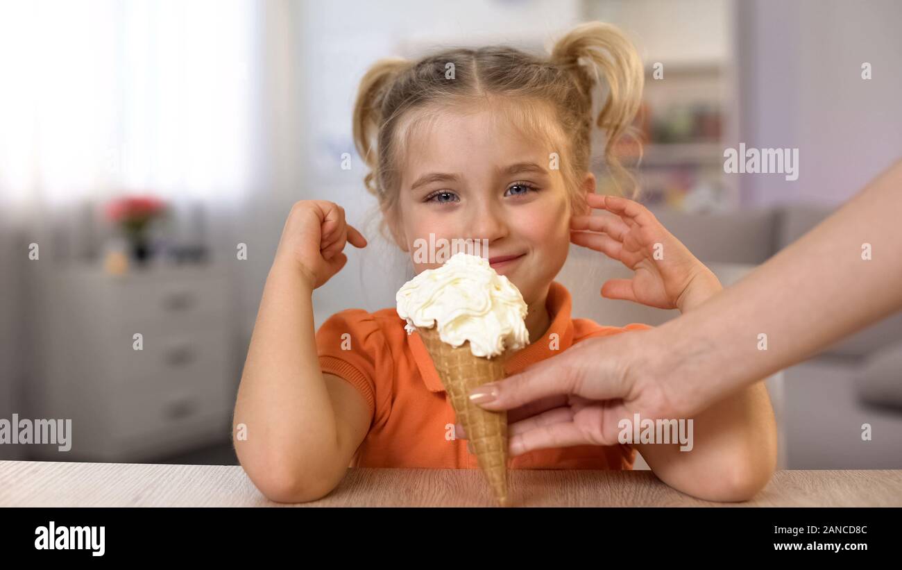 Cute girl ice-cream cone dégustation main de femme, de l'enfance, snack-surprise Banque D'Images