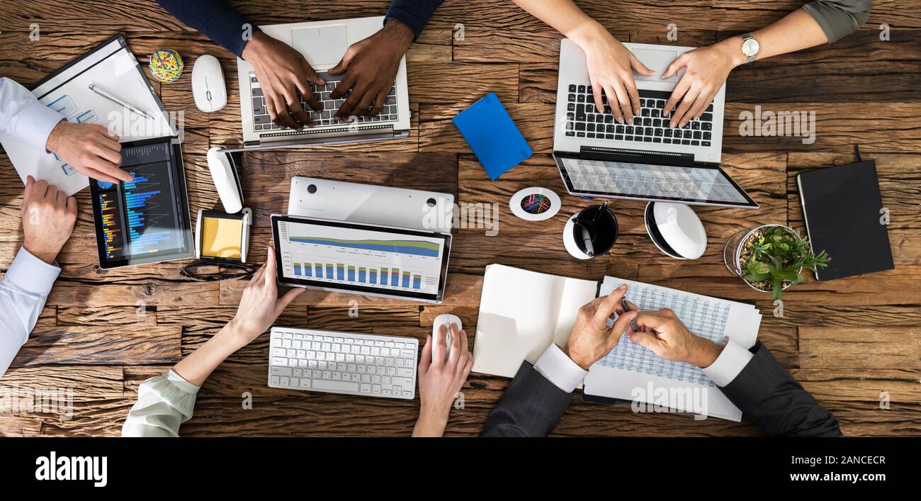 Vue de dessus de la main d'affaires sur 24 avec les ordinateurs portables et de Digital Tablet In Office Banque D'Images