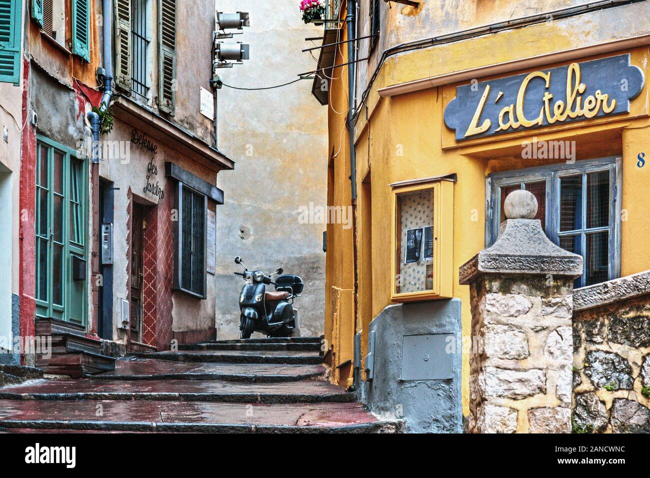 Scooter debout en haut de marches dans une rue piétonne colorée à Nice, France, Europe Banque D'Images